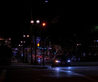 Car driving at night on a city street. smart traffic camera at intersection, night city street, police car lights