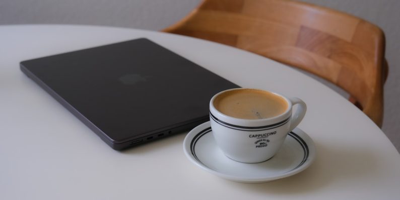 Laptop and coffee cup on a white table creative workspace laptop coffee email interface